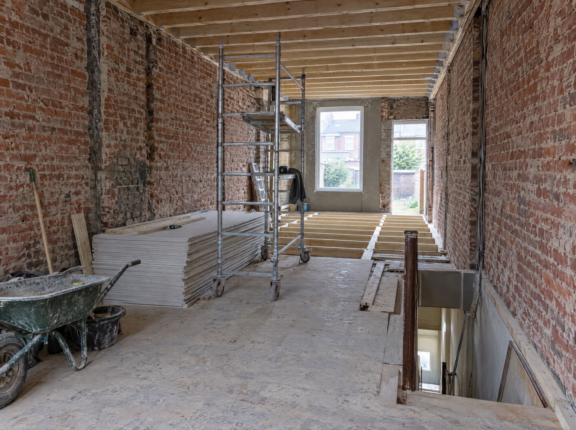 Maison mitoyenne en brique vidée pour une rénovation complète, solives neuves et échafaudage